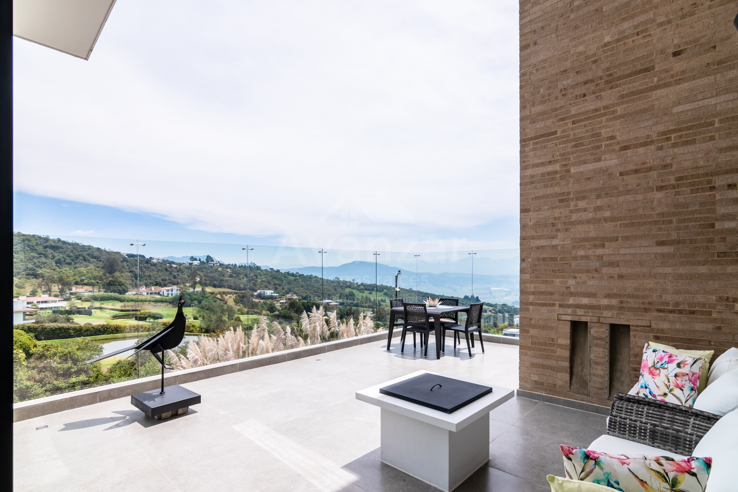 Terraza con baranda de vidrio y vista abierta al campo de golf