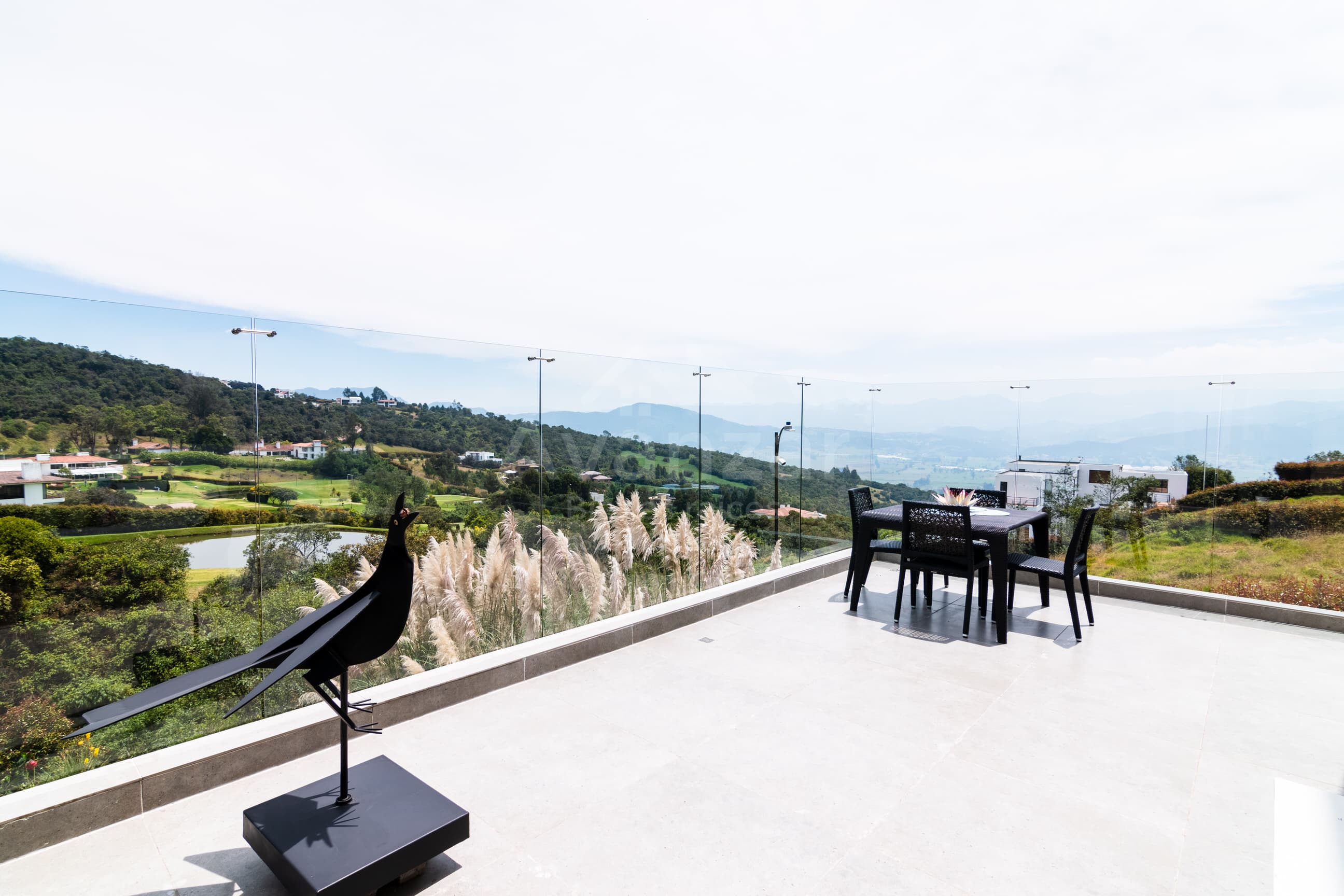 Terraza con vista panorámica al campo de golf y al Valle de Sopó entre la niebla matinal