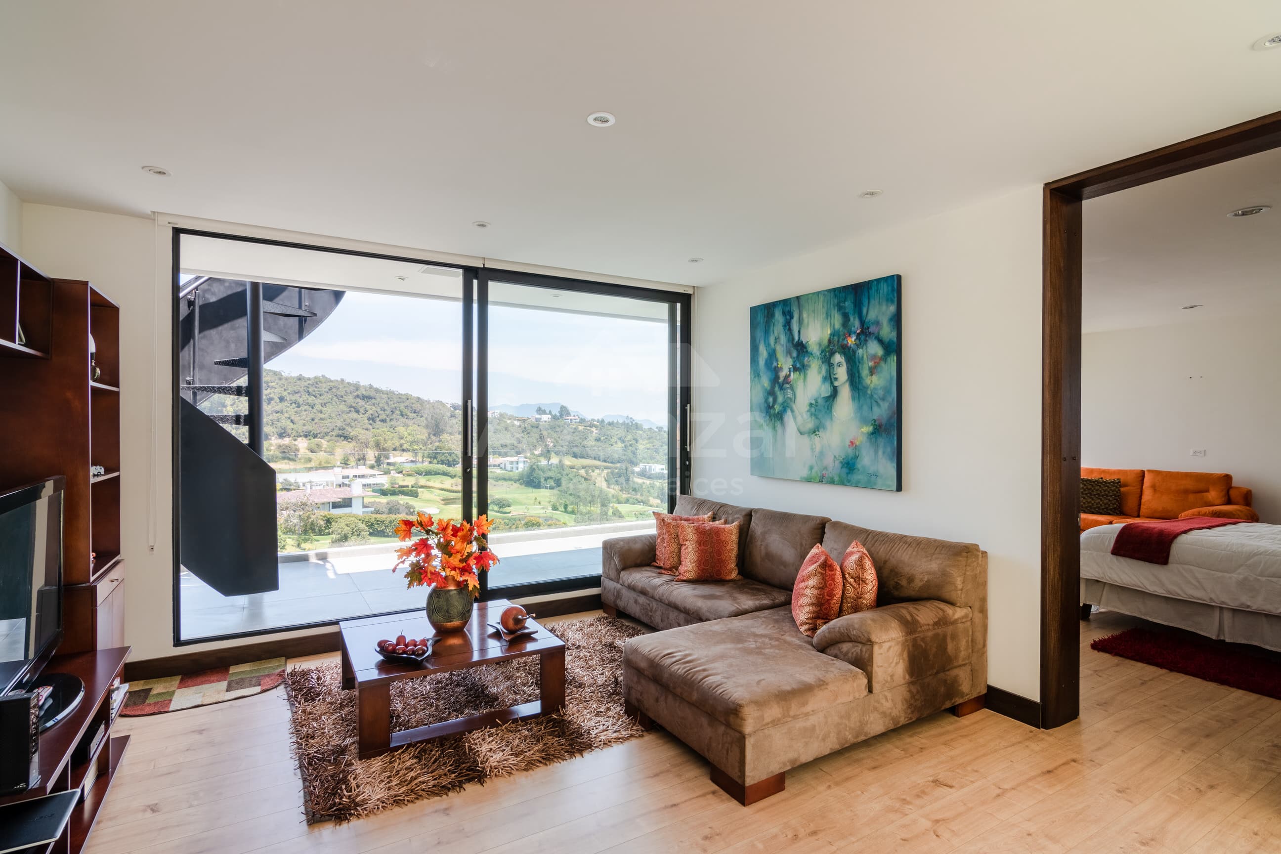 Sala con ventanal panorámico de piso a techo hacia el campo de golf y el Valle de Sopó