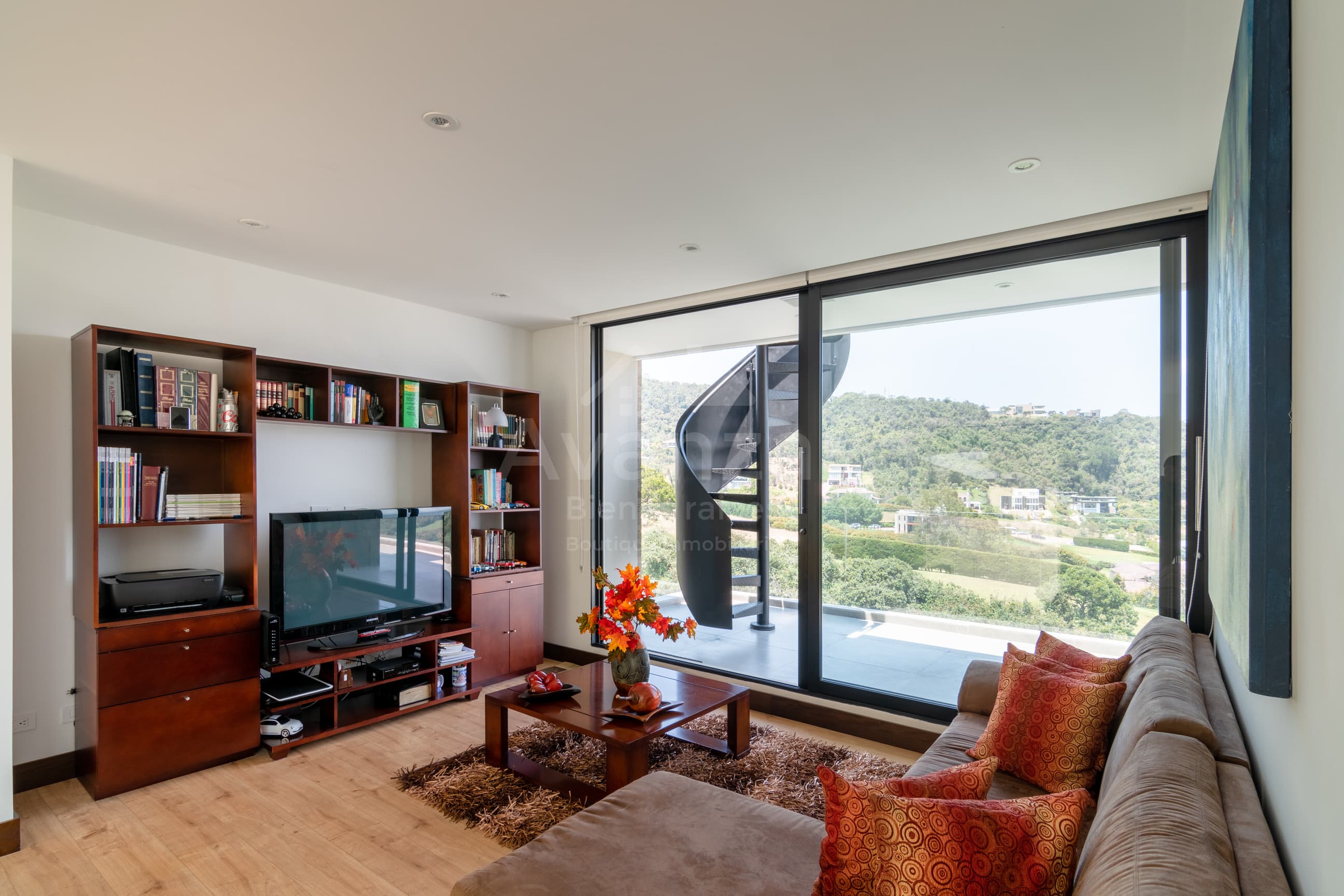 Sala familiar con librero de madera y vista al valle verde