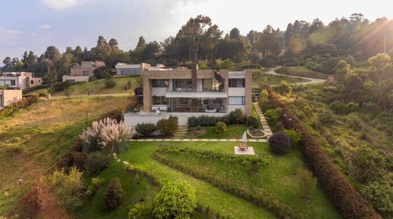 Fachada trasera de la casa al atardecer con jardín paisajístico